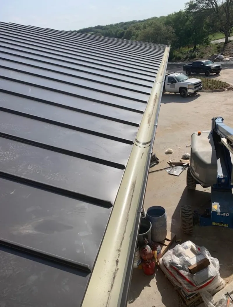 Standing seam panel and gutter detail on a metal roofing jobsite in Walkertown
